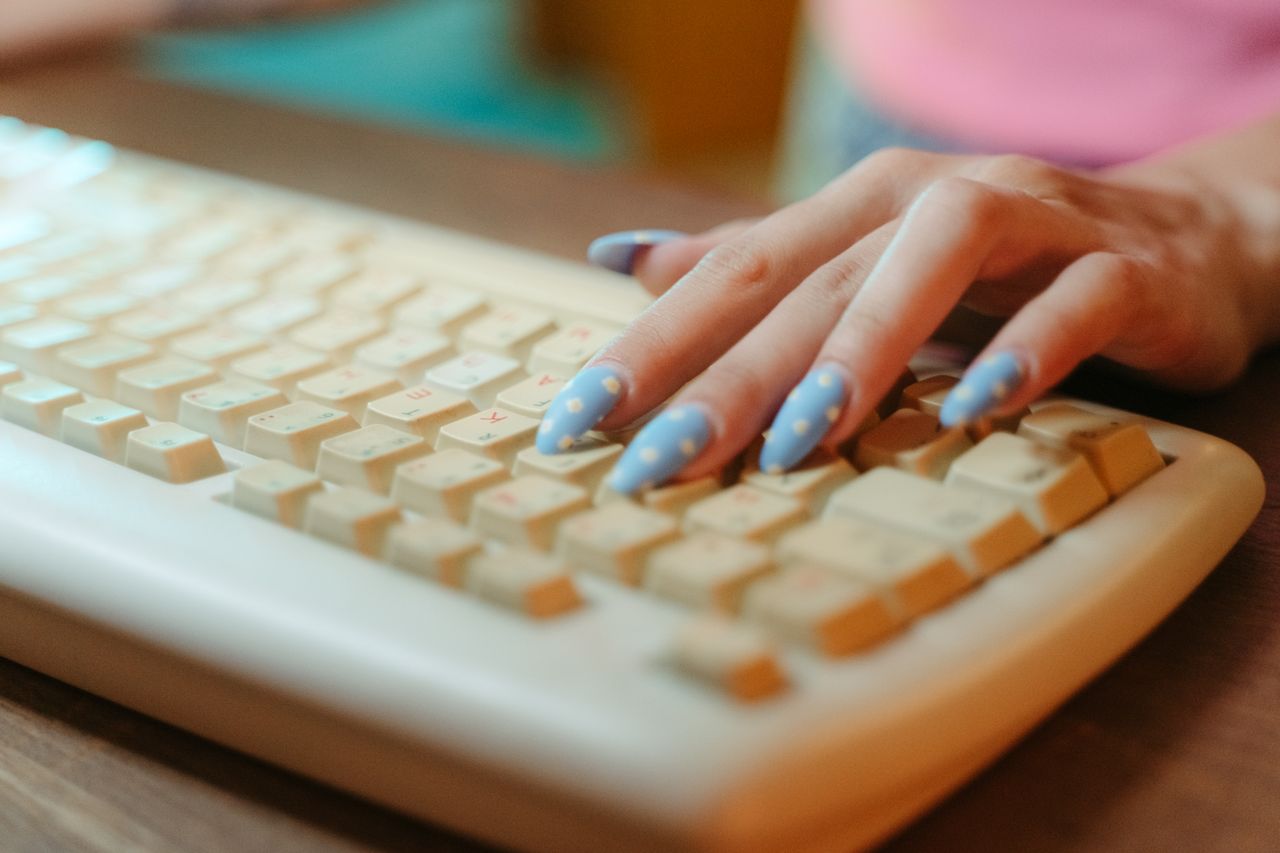 Mãos digitando em um teclado de computador antigo